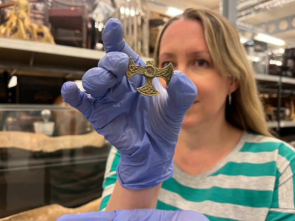 Kat Baxter, curator at Leeds Museums & Galleries, holds the eight century Saxon pendant.