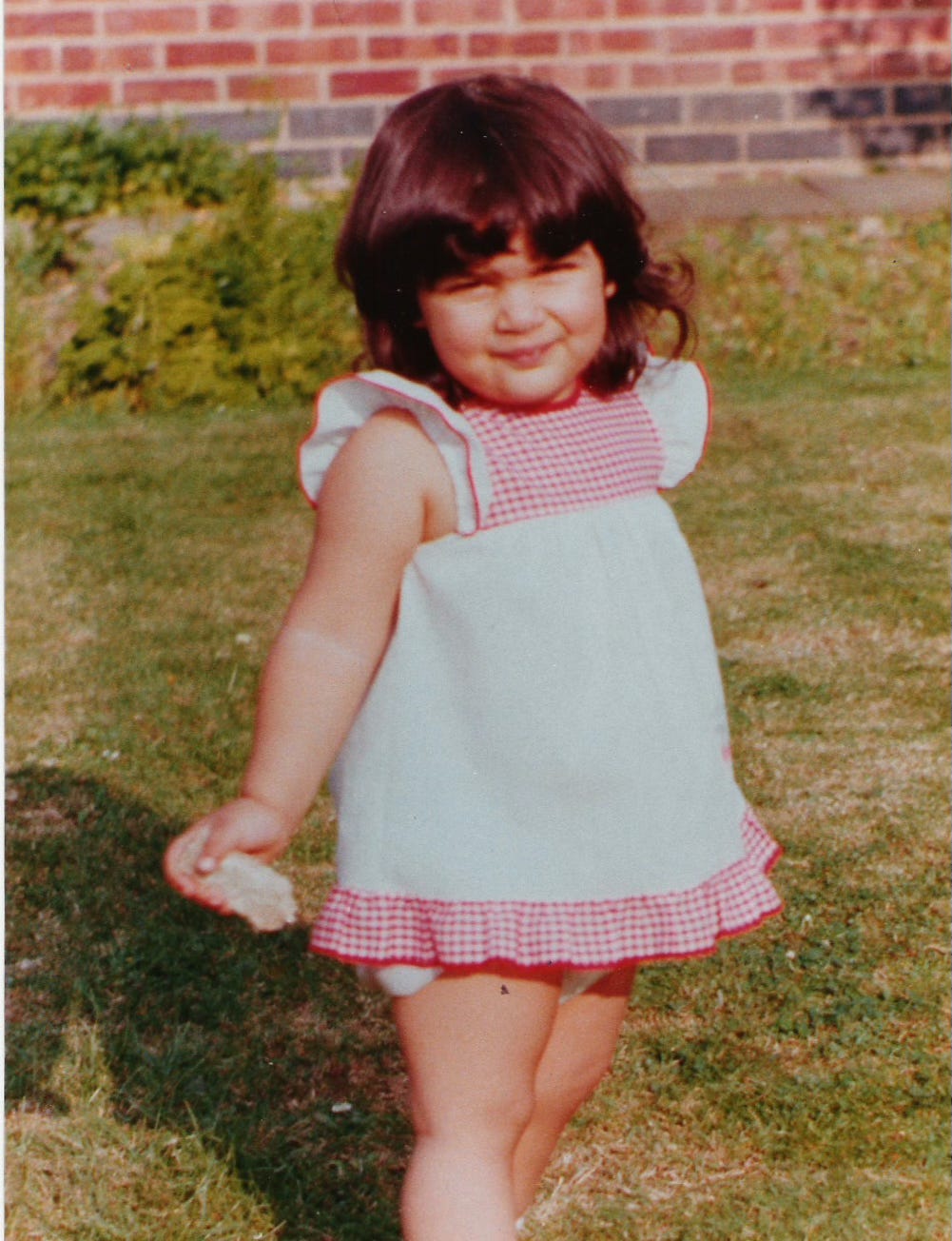 a toddler holding a crust of bread