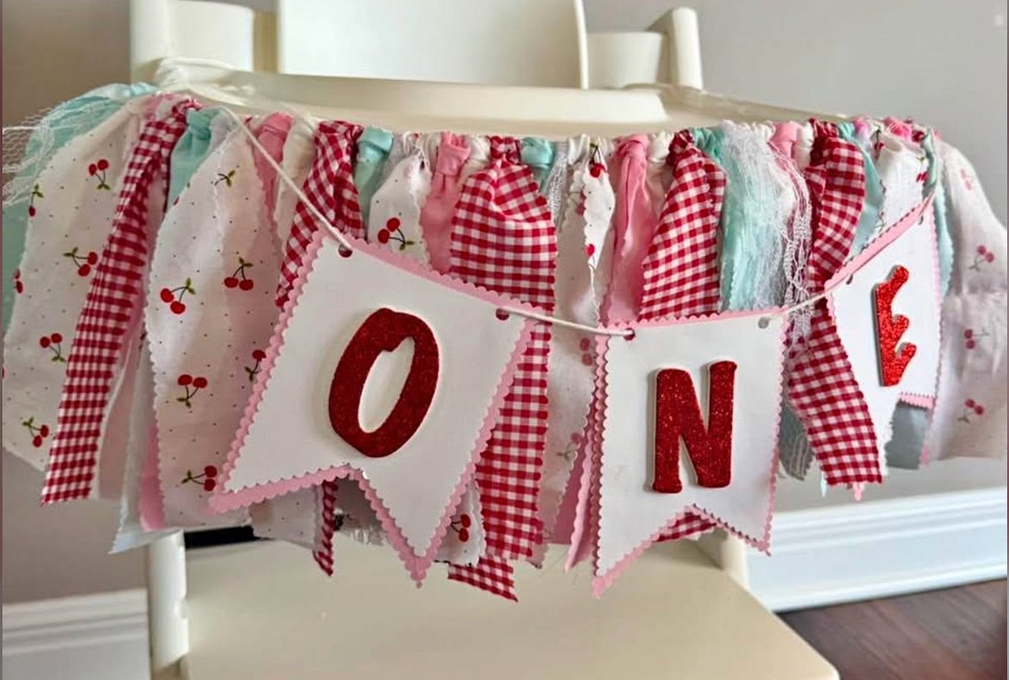 A high chair banner saying "one" A high chair banner saying "one"