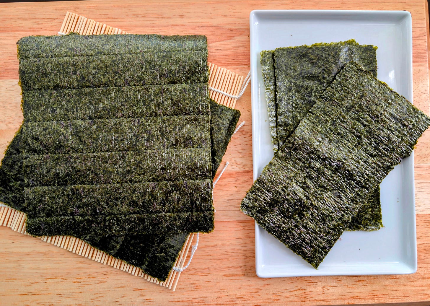 Nori Sheet: A single sheet of glossy, dark green nori with a slightly textured surface, ready to be used for rolling futomaki. The delicate, crisp seaweed contrasts with the smooth sushi rice it will soon wrap. Nori Sheet: A single sheet of glossy, dark green nori with a slightly textured surface, ready to be used for rolling futomaki. The delicate, crisp seaweed contrasts with the smooth sushi rice it will soon wrap.