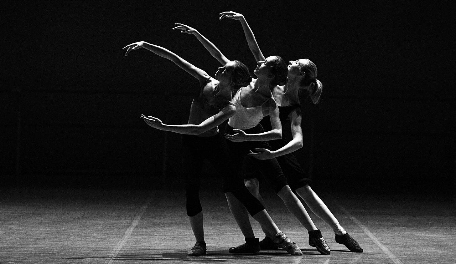 three balerinas make art on the stage