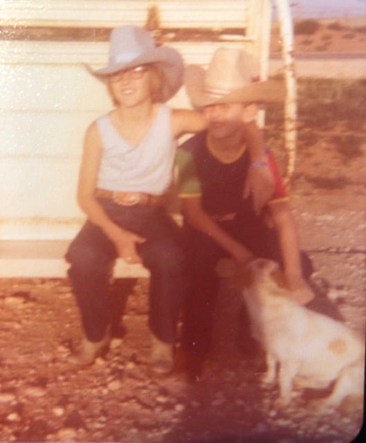 young girl and boy wearing cowboy hats and petting a white dog