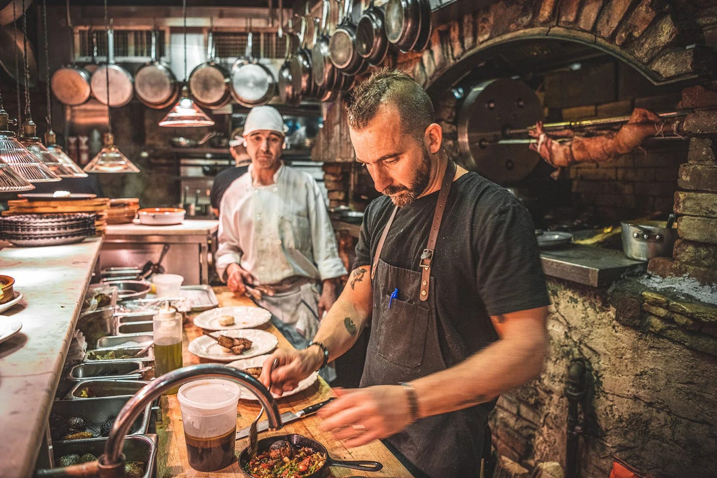 Marc Forgione prepping food in the kitchen of his restaurant Peasant