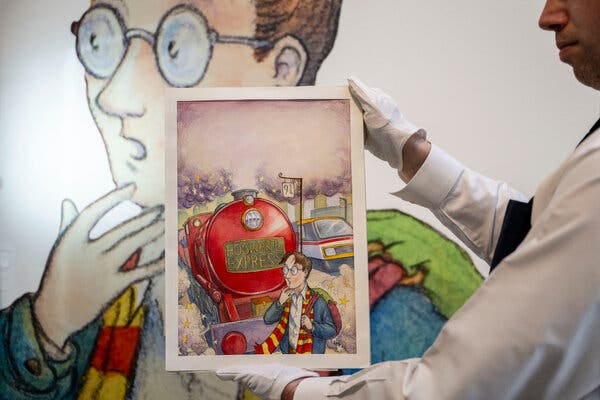 A person wearing white gloves holds up the original cover art for “Harry Potter and the Philosopher’s Stone.” In the illustration, Harry Potter is at a train station and the Hogwarts Express has arrived.