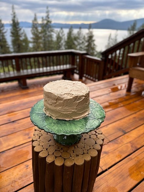 A slice of cake on a plate, frosting a cake, a cake on a plate outdoors