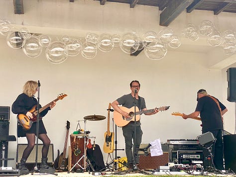 people outside having a party, playing live music and a swimming pool and bbq