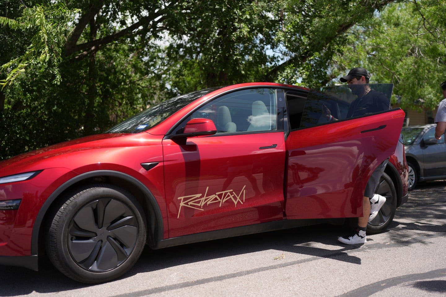 A rider gets into a red driverless Tesla robotaxi in Austin, Texas. A rider gets into a red driverless Tesla robotaxi in Austin, Texas.
