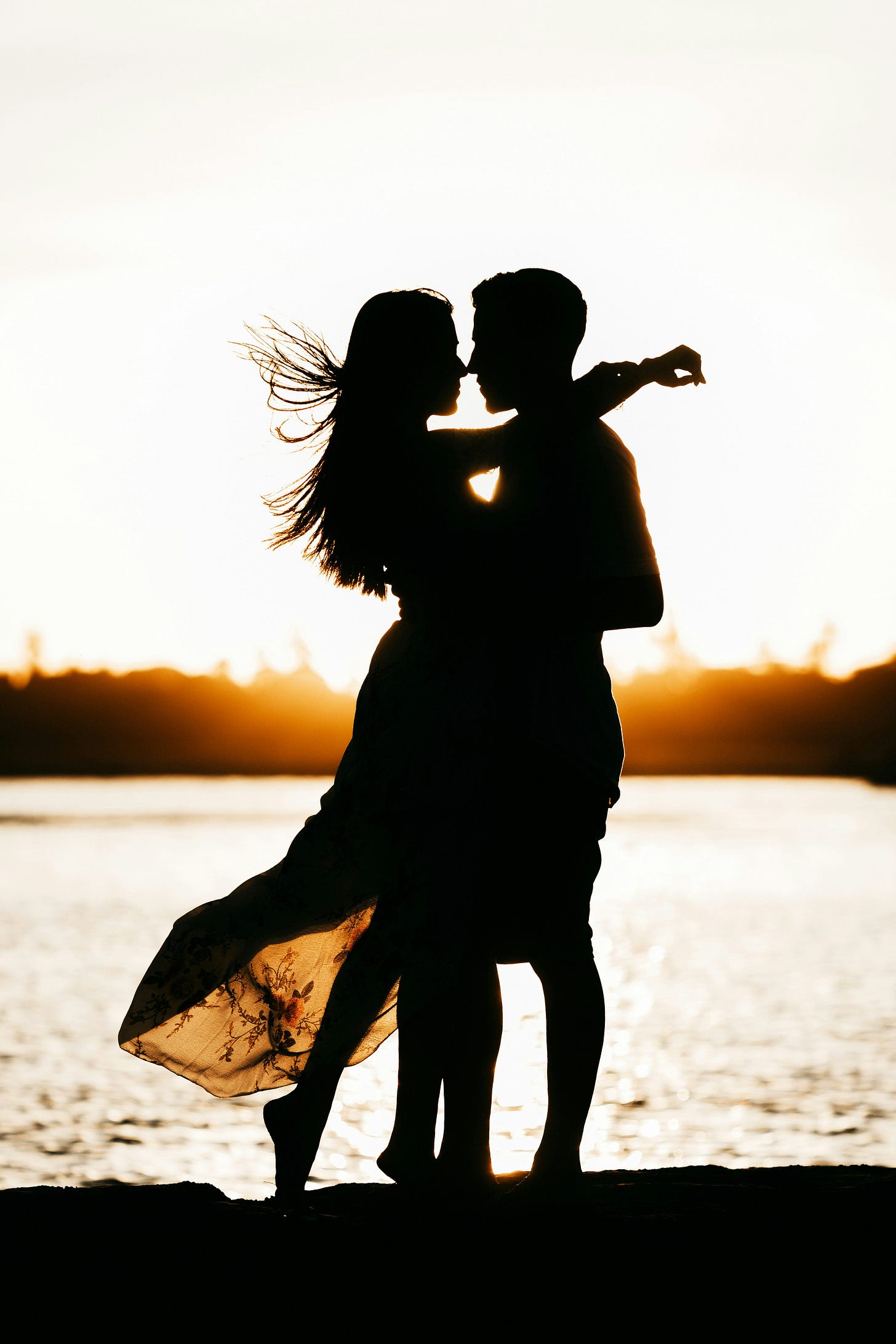 a silhouetted couple embracing