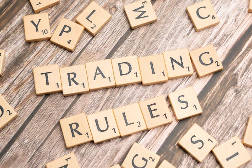 scrabble tiles spelling trading rules on a wooden table scrabble tiles spelling trading rules on a wooden table