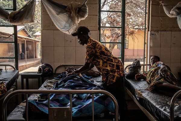 Abu Kamara tended to his mother, Ramatu Sesay, in the hospital at Kamakwie, Sierra Leone. The hospital wards contain cancer and malaria patients, but none with Covid.