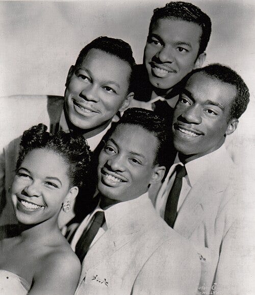 Black and white photo of ‘The Platters’, posing closely together in a classic mid-20th-century studio portrait style. Picture Source: Wikipedia