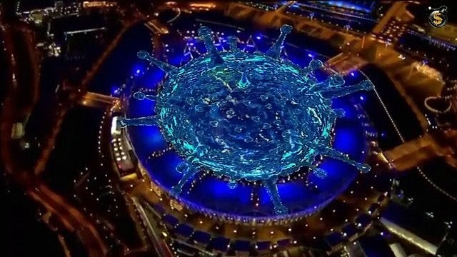 Scene from the 2012 London Olympics opening ceremony showing large stadium projection representing a virus.