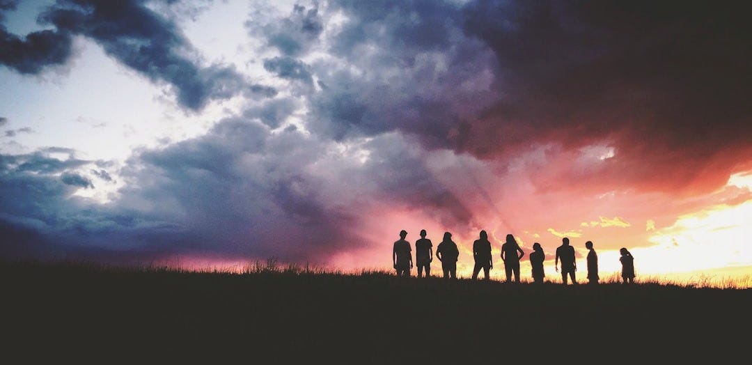 silhouette of nine persons standing on the hill silhouette of nine persons standing on the hill