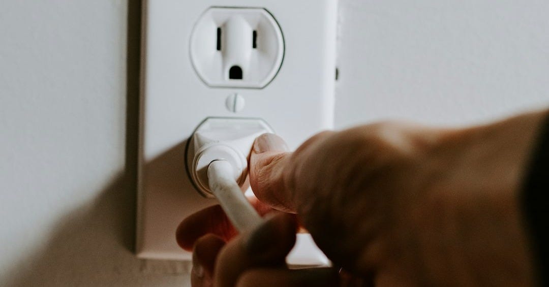person holding white electric plug