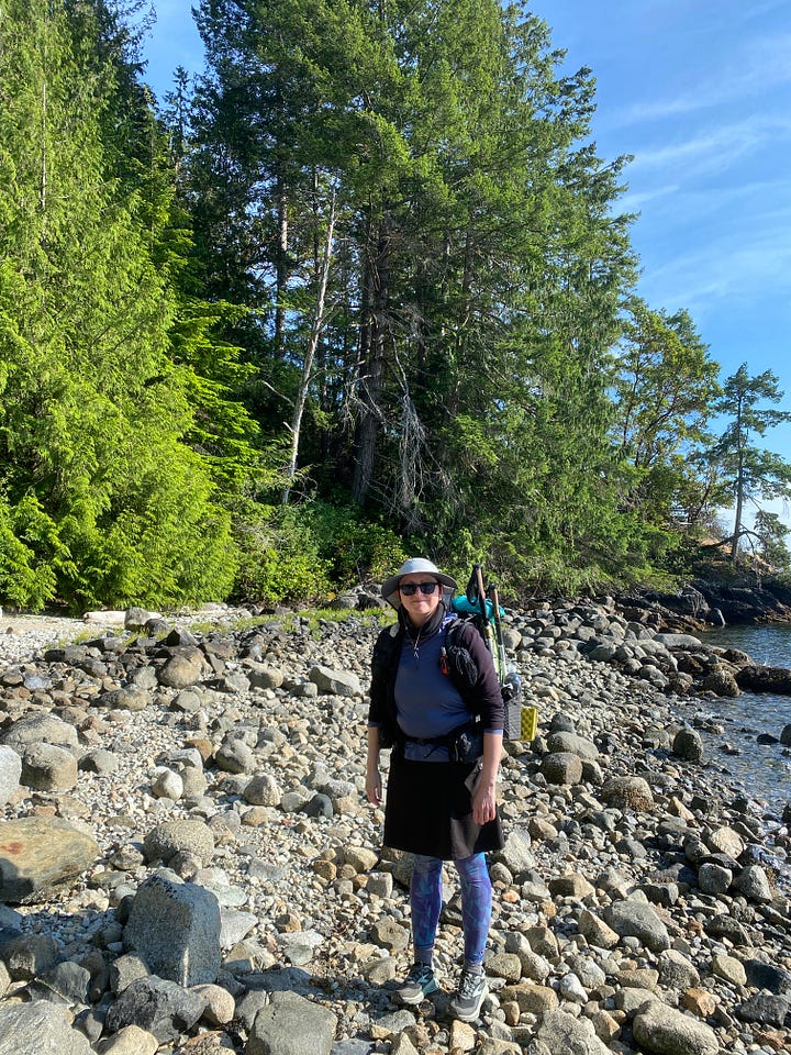Four photos of the Sunshine Coast Trail. 1. A hiker with a full backpack (me) on a rocky beach at Sarah Point. @ and 3. Forest trails, one bathed in sunlight and the other in mist. 4. A calm lake reflecting a hill and sunny sky, with dead tree trunks lying in the water.