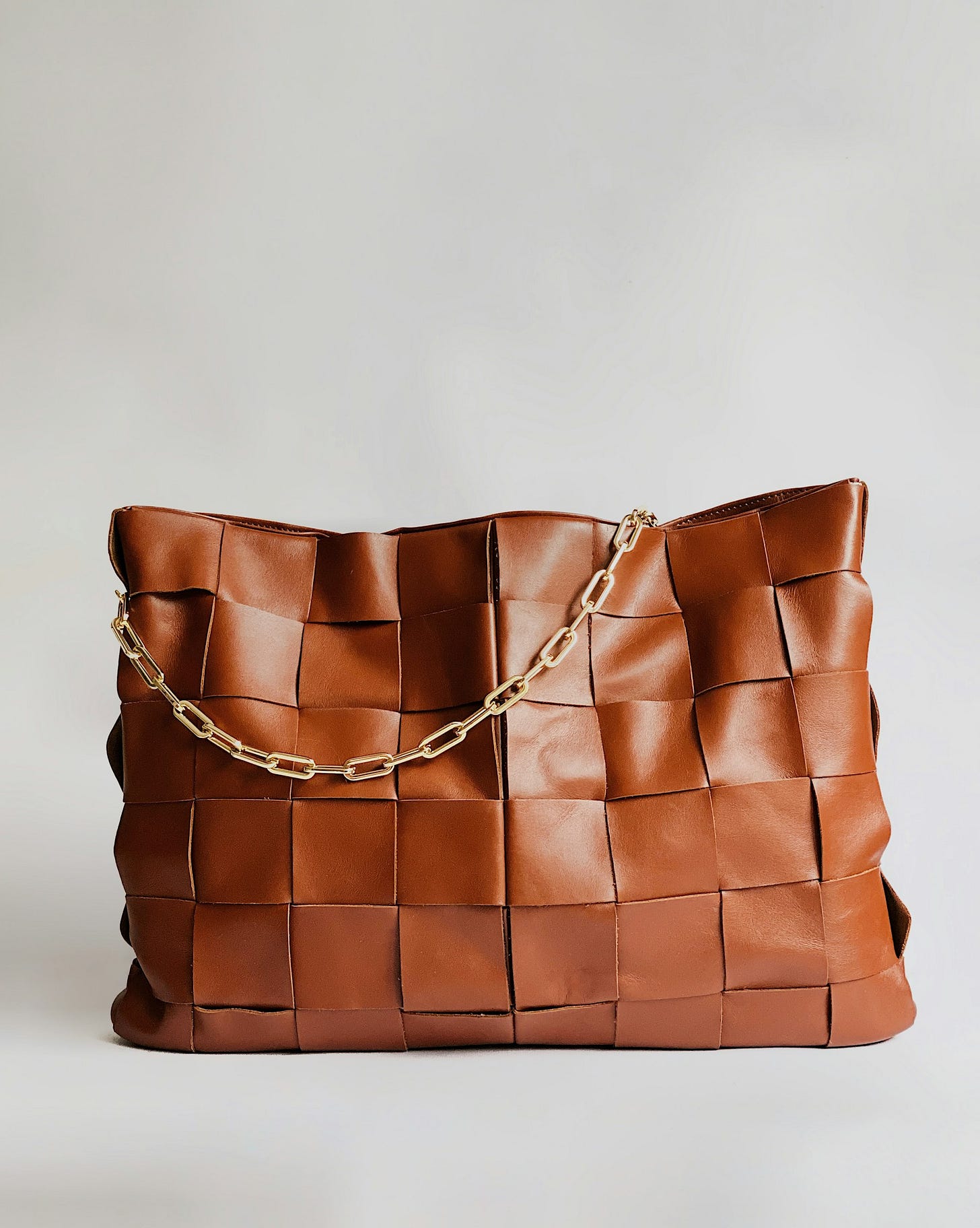 brown leather handbag on white surface brown leather handbag on white surface