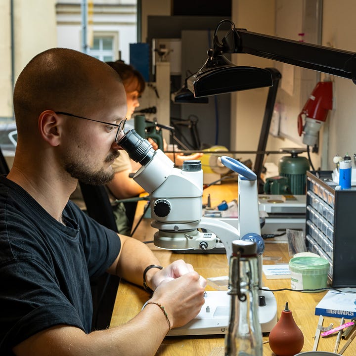 Two watchmakers finishing components at Kallinich Claeys