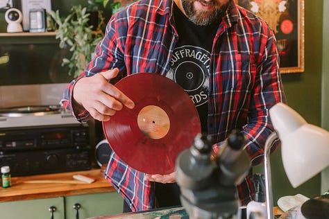 1 & 4 Oberon and Xanthe chat about preloved records with the local community. 2. Oberon shows an eco-vinyl record made from waste plastics in a carbon neutral process. 3. Oberon demonstrates his method of record repair, with a microscope. 5. Oberon shows a young visitor how to care for record players and how they work.