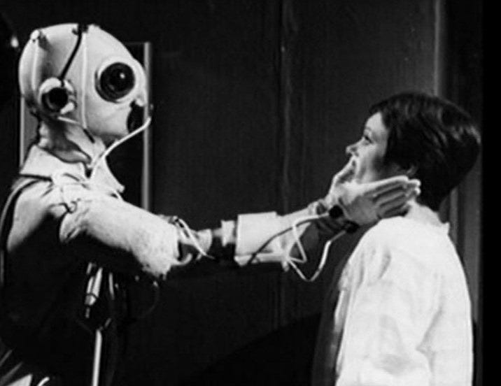 George, in a cybernetic suit, reaches out to touch Anna's face