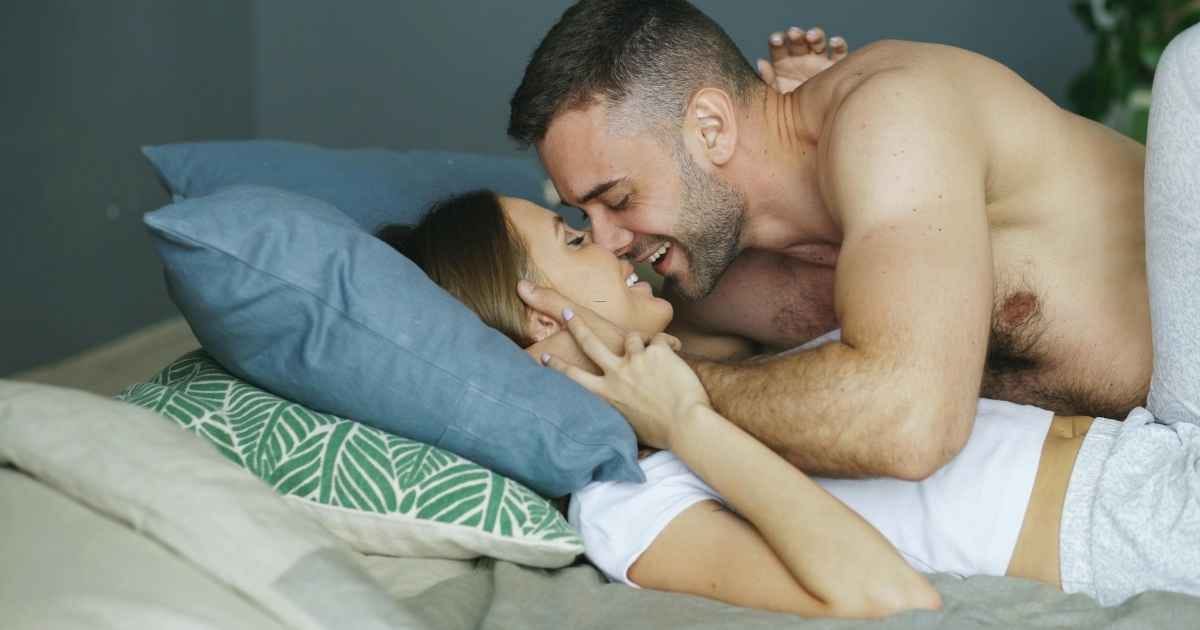 Romantic Couple Laughing on a Cozy Bed