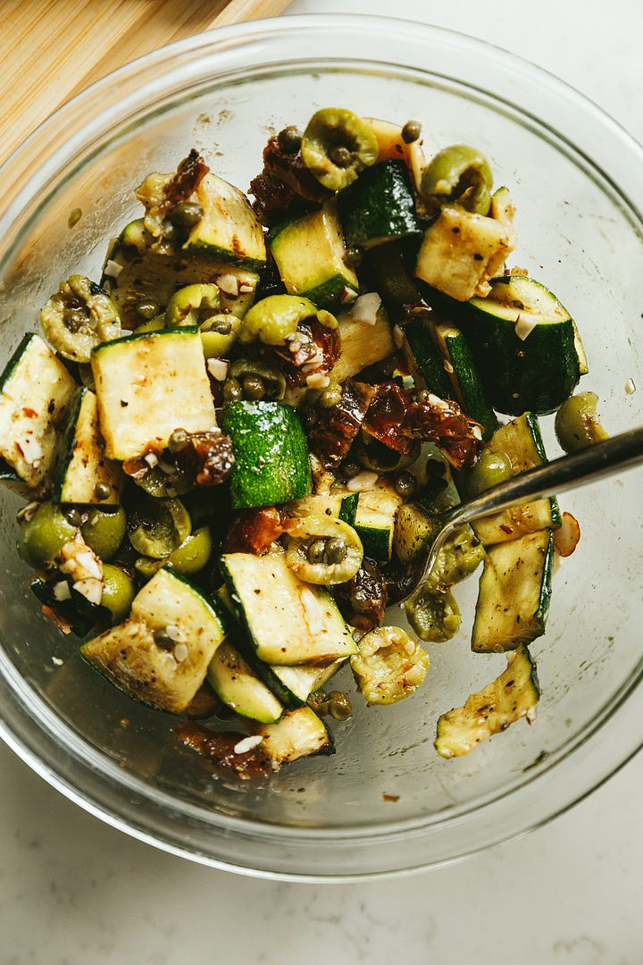 Spatchcock grilled oregano chicken and a warm zucchini salad with olives, dates, and capers.