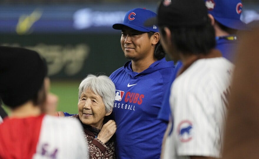 Chicago Cubs starting pitcher Shota Imanaga, center right, poses for photos with fans after the team's MLB Japan Series baseball game against the Los Angeles Dodgers in Tokyo, Japan, Tuesday, March 18, 2025. (AP Photo/Hiro Komae)