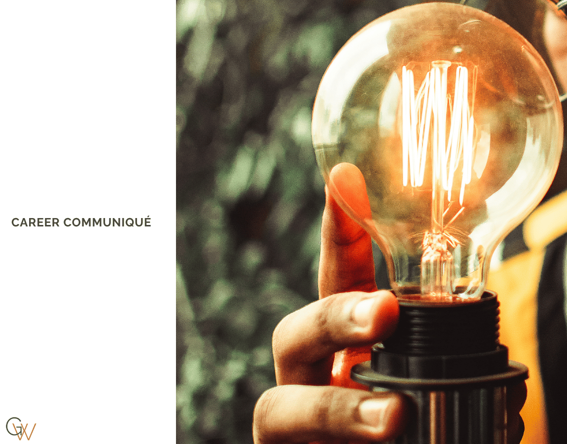 A close-up photograph of a hand gripping a large Edison-style incandescent bulb by its base, with the carbon filament glowing amber inside the glass globe. The background is softly blurred in deep green and warm gold tones. Career Communiqué branding and the Geneèn Wright logo appear on the left against a white panel. A close-up photograph of a hand gripping a large Edison-style incandescent bulb by its base, with the carbon filament glowing amber inside the glass globe. The background is softly blurred in deep green and warm gold tones. Career Communiqué branding and the Geneèn Wright logo appear on the left against a white panel.