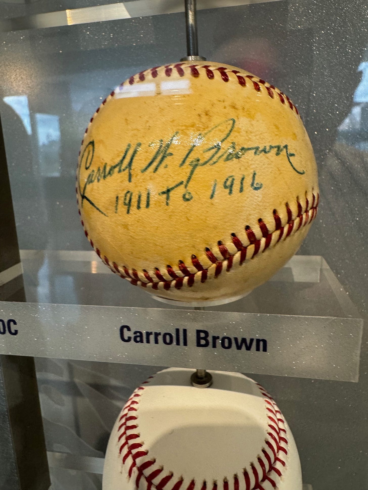 Close up of yellowish baseball signed "Carroll W. Brown, 1911 - 1916."