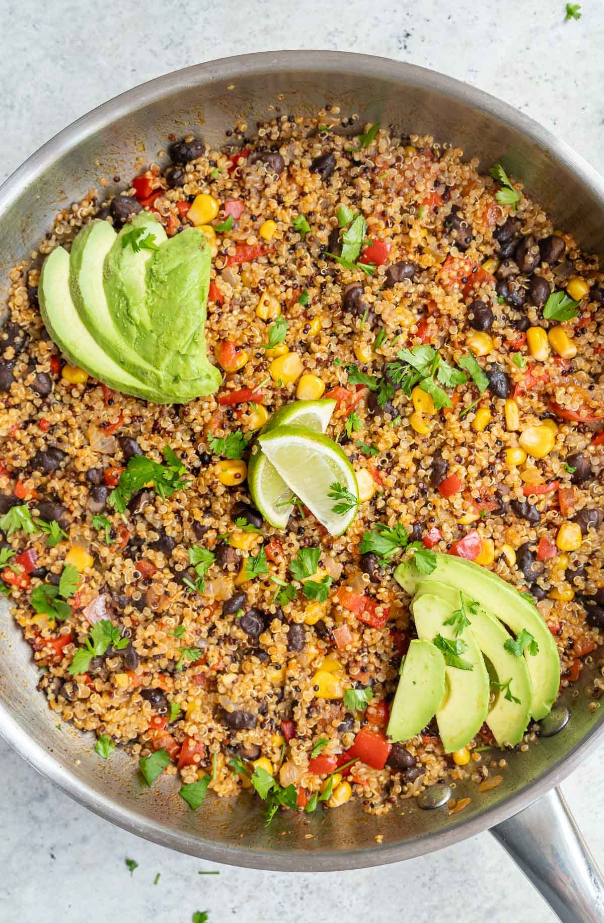 Mexican Quinoa served with sliced avocado and chopped cilantro.