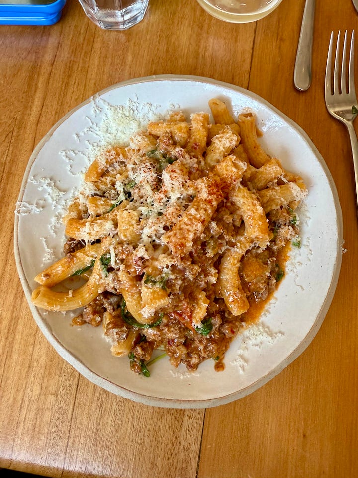 plate with fish and courgette and plate of pasta with ragu