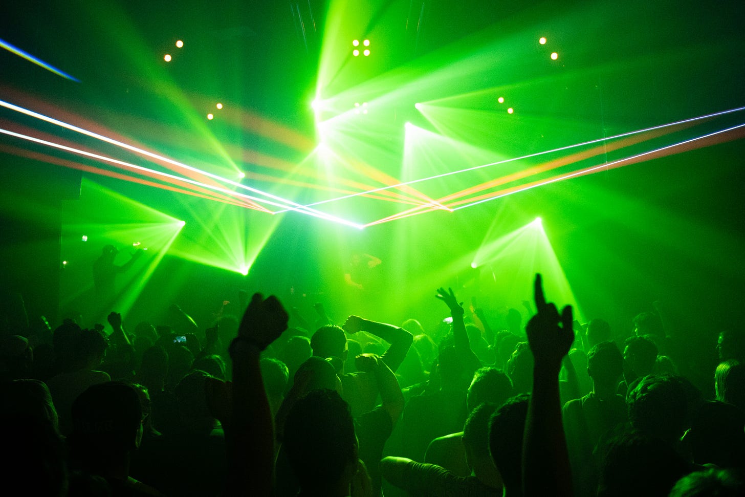 People dancing and partying in green strobe lights