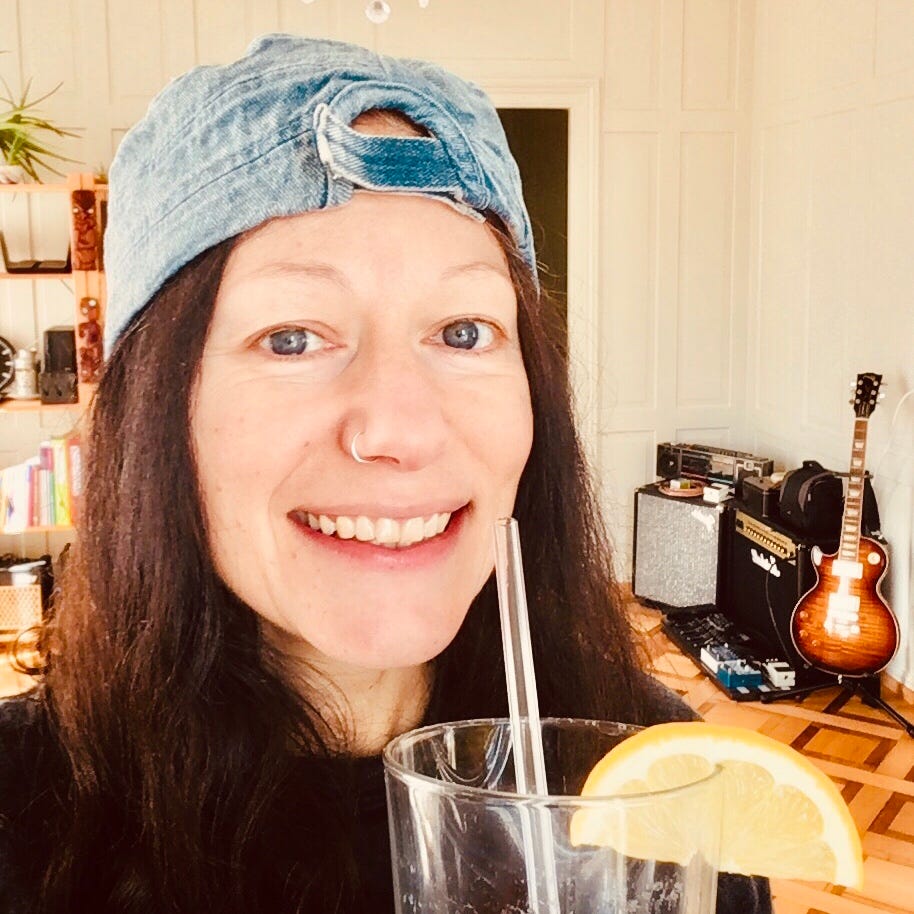 female baseball cap long brown hair drinking lemon water guitar amps heritage house