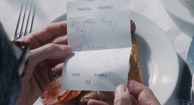 This may contain: two people holding up some food on top of a white plate with writing on it