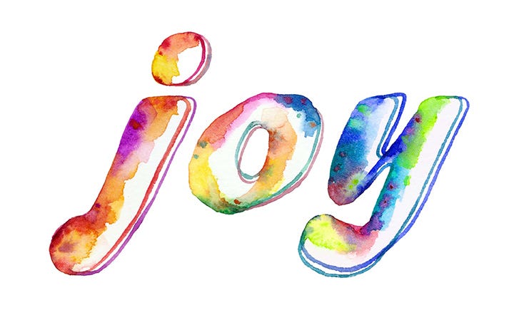 The word "joy" painted in rainbow colors on a white background