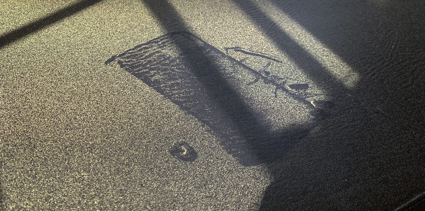 A close up of a black piano bench covered in yellow pollen