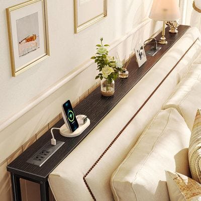 This may contain: a living room with a couch, table and pictures on the wall next to it