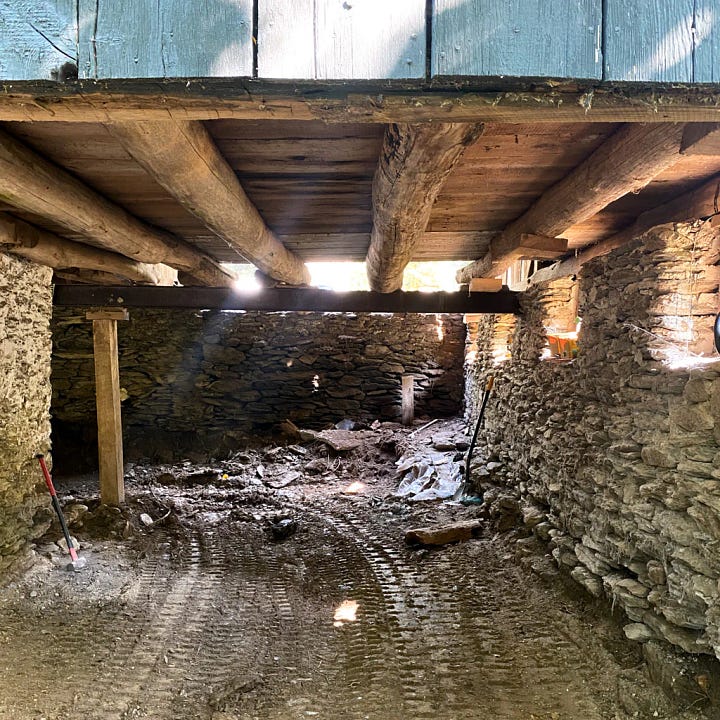 Image of American Chestnut tree beams underneath the barn floor and an image of new wood and glass doors which is the entrance to the barn, doors made by Walter Kent.