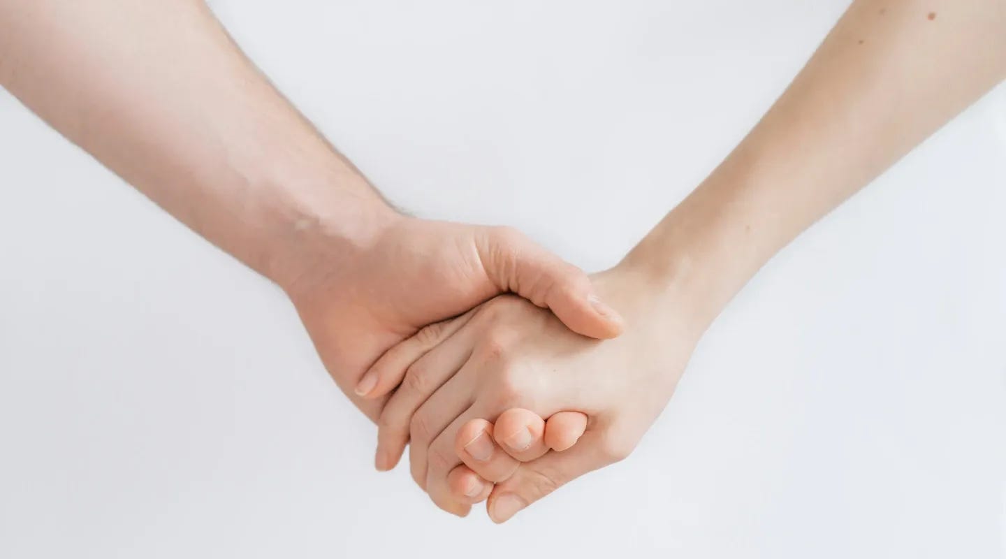 Dos manos humanas sosteniéndose.