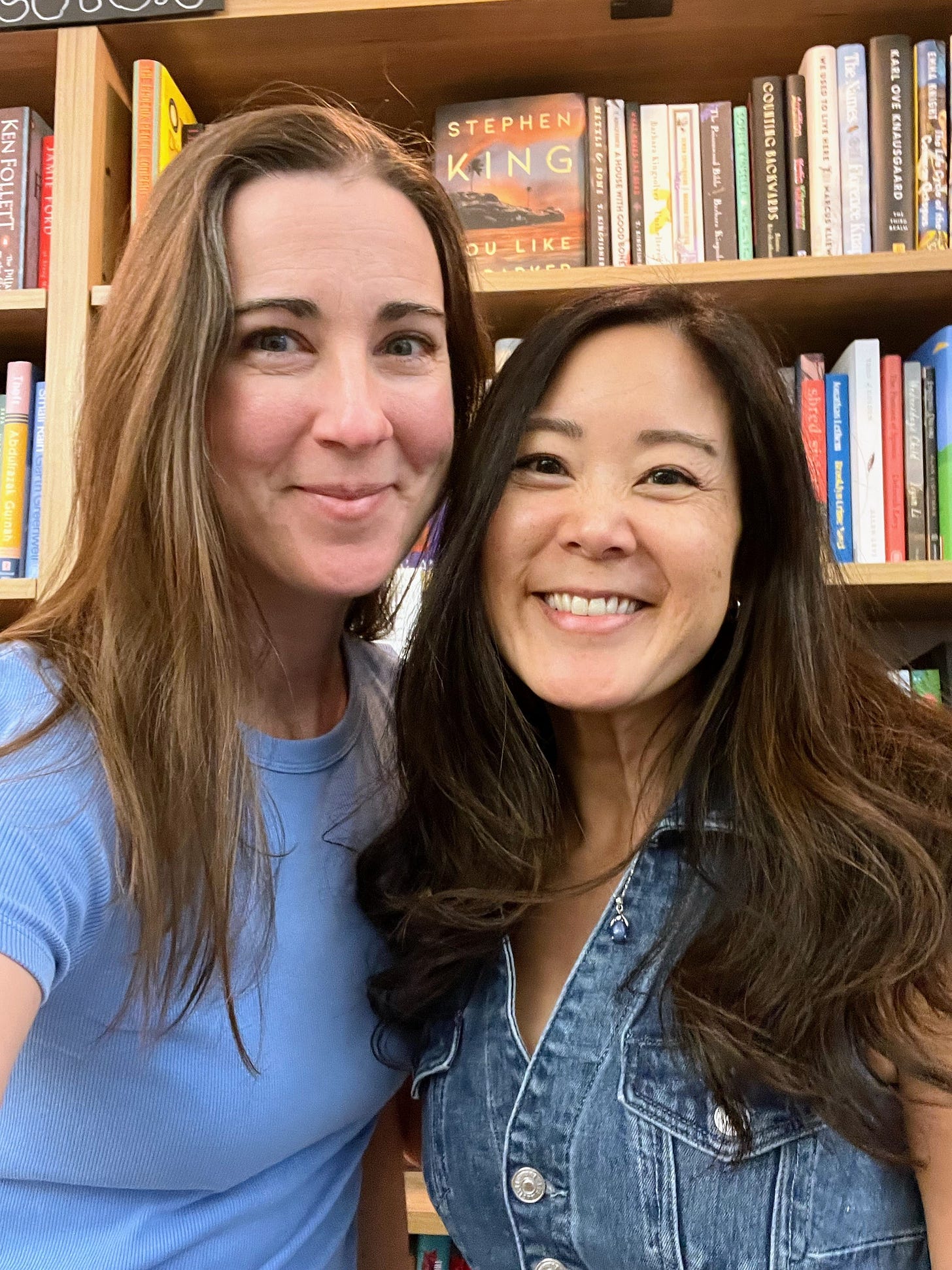 Joanna Phoenix and Evelyn Skye both wearing blue inside a bookstore