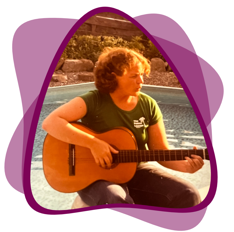 The author, around age 20, playing guitar and singing beside a pool