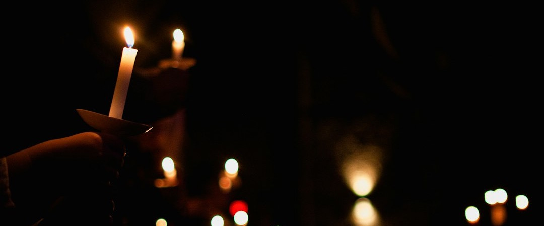 person holding lighted candle during night time