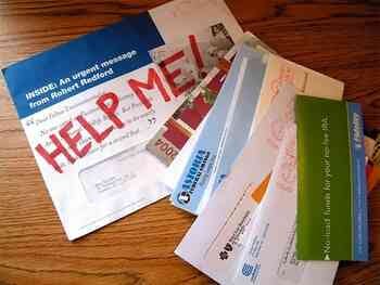 An opened mailer with "HELP ME!" written on one sheet of paper