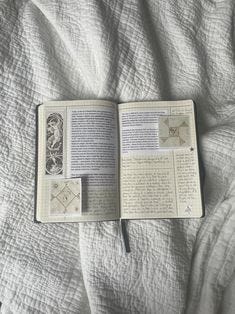 This may contain: an open book sitting on top of a bed
