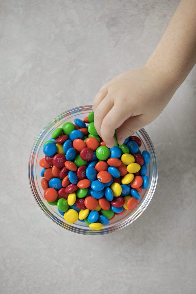 A bowl of colorful chocolate filled candies for M&M cookie bars. | lifemadesimplebakes.com