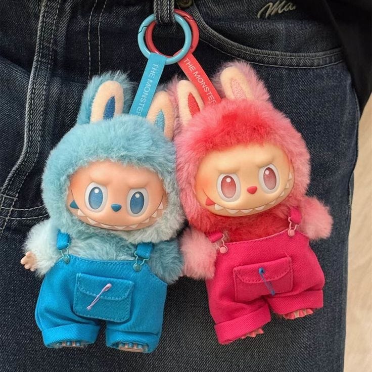 This may contain: two small stuffed animals are attached to the back of a person's jean pants