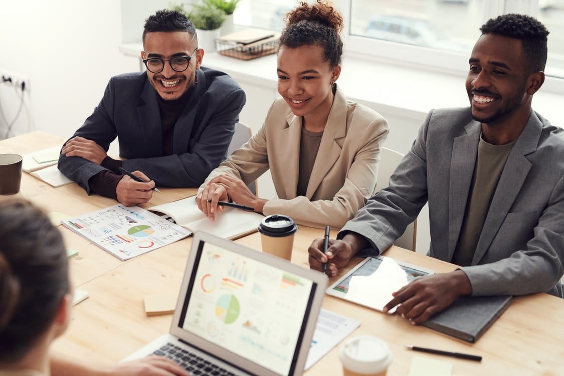 Photo of Three People Smiling While Having a Meeting Photo of Three People Smiling While Having a Meeting