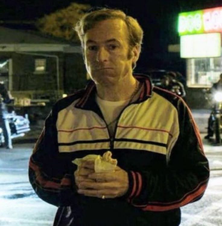 This may contain: a man standing in the street eating something