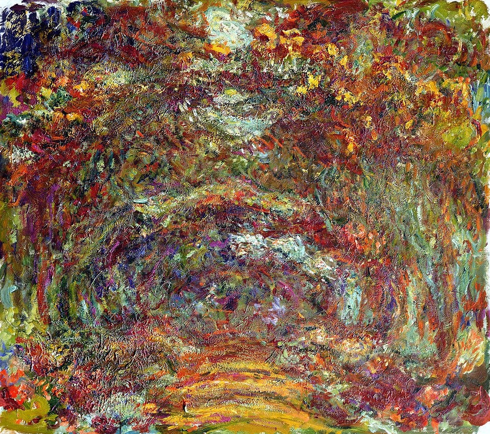 Claude Monet’s painting The Roseway in Giverny. The scene shows a curved pathway disappearing into the distance, bordered on both sides by blooming rose bushes and foliage. The roses are painted in shades of pink and red, blending into the surrounding greenery. The pathway, and some parts of the brushes are yellow. 