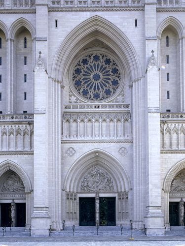 a large cathedral with two doors and a clock on it's front side wall
