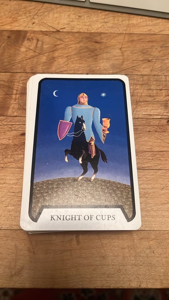 Knight of Cups tarot card showing an armoured rider holding a golden cup beneath a night sky Knight of Cups tarot card showing an armoured rider holding a golden cup beneath a night sky